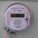 A residential power meter on a home's exterior.